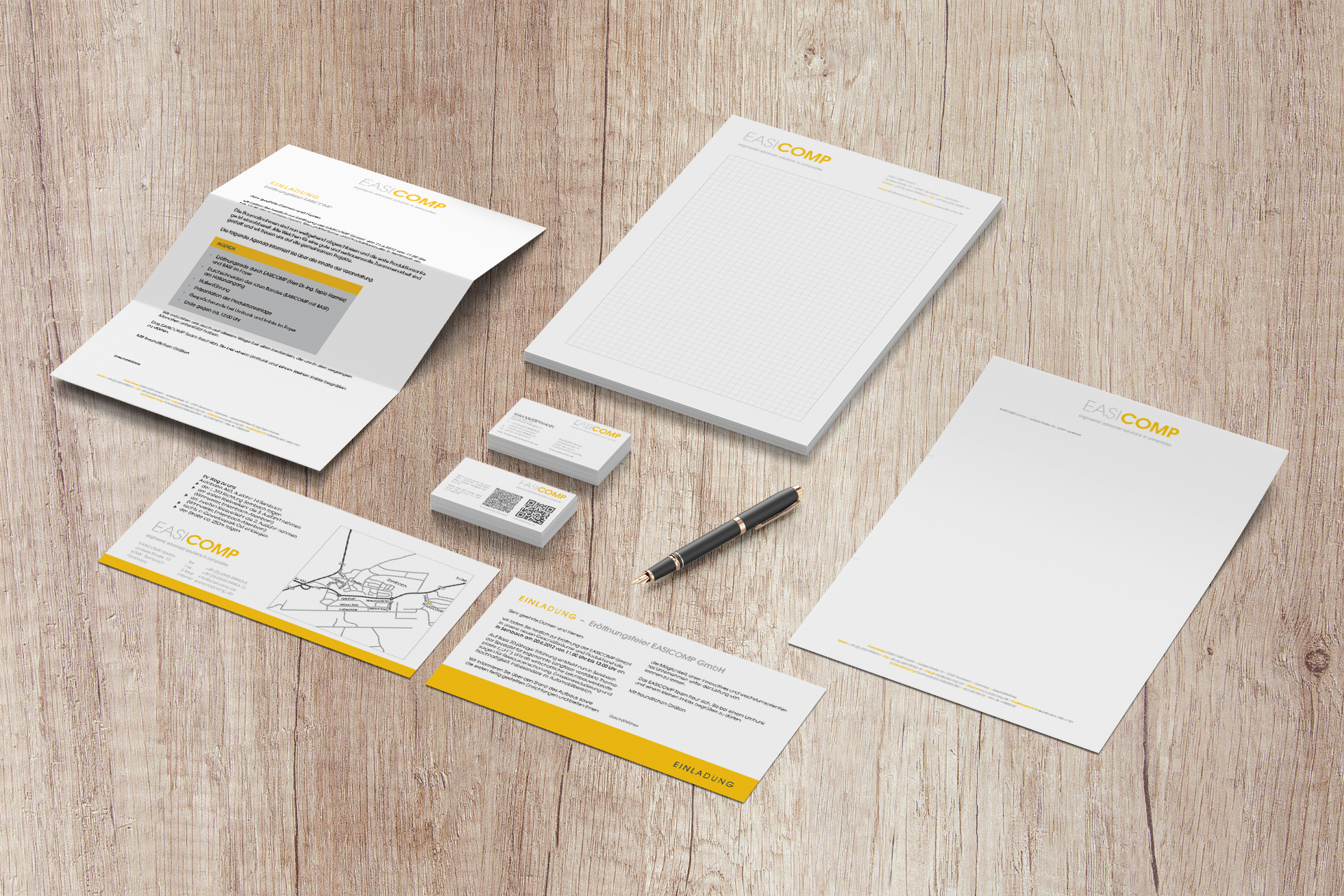 Geschäftspapiere für die EASICOMP GmbH, wie z. B. Rechnungspapier, Visitenkarten, Einladung zur Eröffnung, karierter Schreibblock.